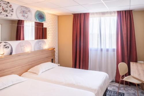 a hotel room with two beds and a window at Brit Hotel Nantes La Beaujoire Parc Expo in Nantes