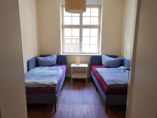 sala de estar con 2 camas y ventana en FeWo am Jacobikirchhof, en Stendal
