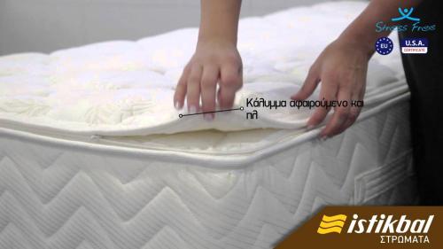 a person is laying a mattress on a bed at Thea Apartment in Agia Marina Nea Kydonias