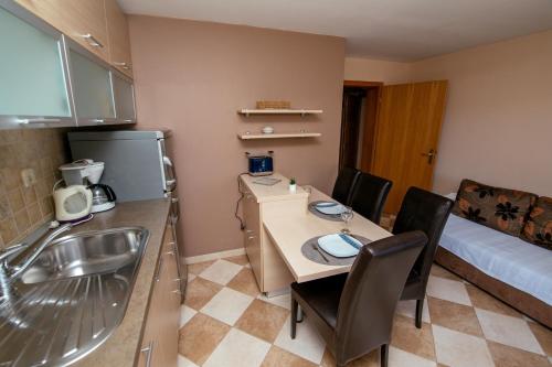 a small kitchen with a sink and a table in a room at M&M Apartments in Biograd na Moru