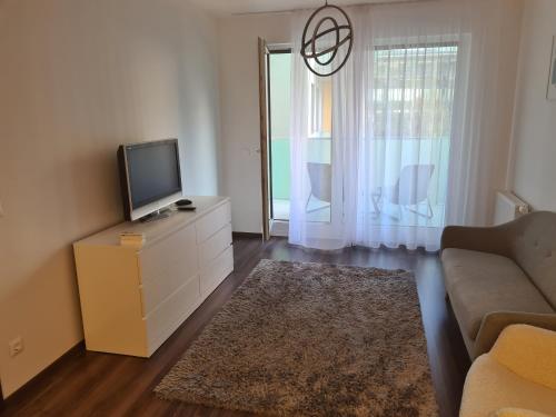 sala de estar con sofá y tocador con TV en Aphrodité apartman, en Budapest
