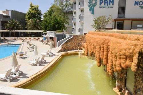 a pool at a resort with chairs and a swimming pool at Pam Thermal Hotel Clinic & Spa in Pamukkale