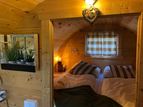 sypialnia z łóżkiem w drewnianym domku w obiekcie Schlaffass - Schlafen im Holzfass Thallern w mieście Gumpoldskirchen
