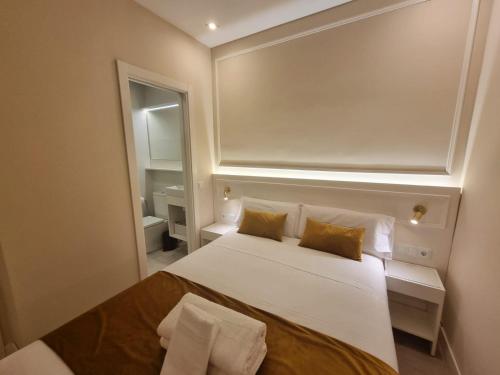 a bedroom with a large white bed and a mirror at CH Velarde in Madrid