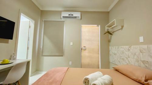 um quarto com uma cama com toalhas em Kalug - Suíte CASAL independente em Guest house em Ilhéus