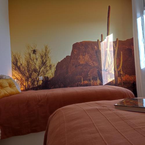 - une chambre avec un lit orné d'une fresque murale représentant la montagne dans l'établissement Maison la grande serre, à Blaslay