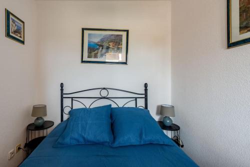 - une chambre avec un lit bleu et deux lampes dans l'établissement Mer et soleil, à Bormes-les-Mimosas
