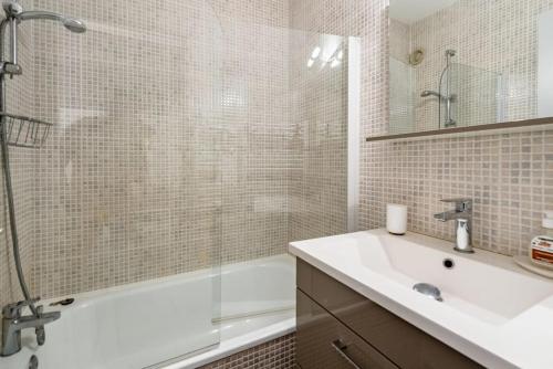 une salle de bain avec un lavabo, une douche et une baignoire dans l'établissement Mer et soleil, à Bormes-les-Mimosas