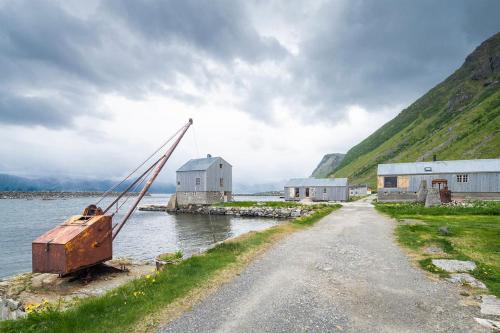 a boat sitting on the side of a body of water at Villa Lofoten - The Saltery in Kvalnes
