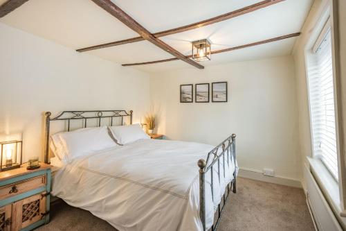 a bedroom with a large bed and a window at Smugglers Cottage in Christchurch