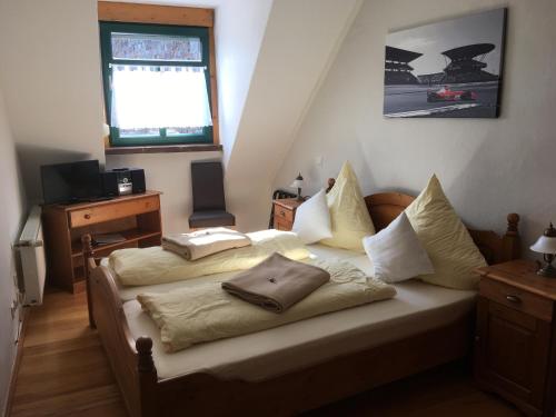 1 dormitorio con 2 camas y TV. en Ferienwohnung Zur Scheune, en Boos
