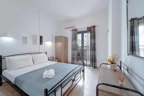Un dormitorio con una cama con zapatos blancos. en Marousi Rooms, en Perissa