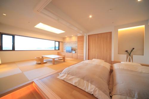 a bedroom with two beds and a table at Awaji International Hotel The Sunplaza in Sumoto