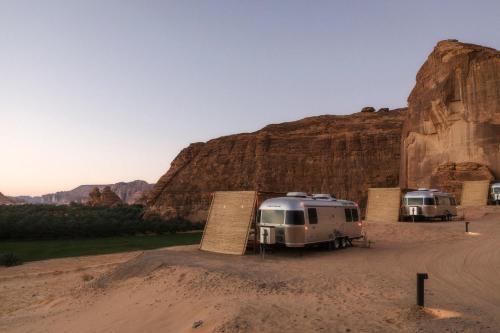 two rvs parked in a dirt field next to a mountain at Caravan AlUla by Our Habitas in AlUla