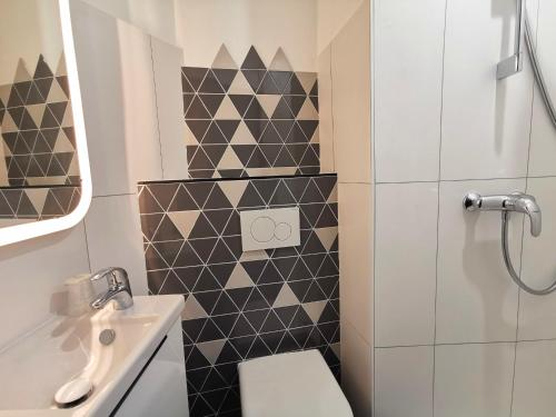 une salle de bain avec toilettes et lavabo dans l'établissement Hotel Alnea, à Cannes