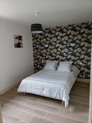 ein Schlafzimmer mit einem großen Bett mit einer Wand in der Unterkunft Gîte T3 Sarlat d'oie in Sarlat-la-Canéda