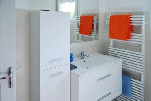 a white bathroom with a sink and a mirror at Maison luxueuse Louargat, jardin B in Louargat