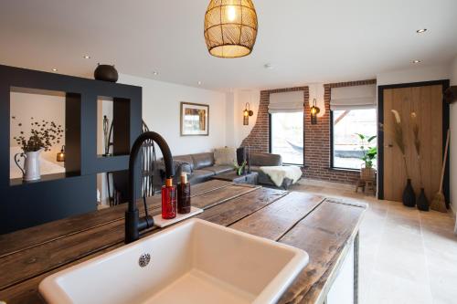 a kitchen with a sink and a living room at BijJoop in Kalenberg