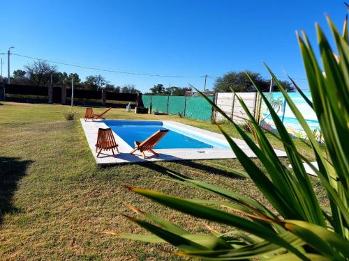 - une piscine avec 2 chaises à côté dans l'établissement Cabaña La Nena, à Santa Rosa