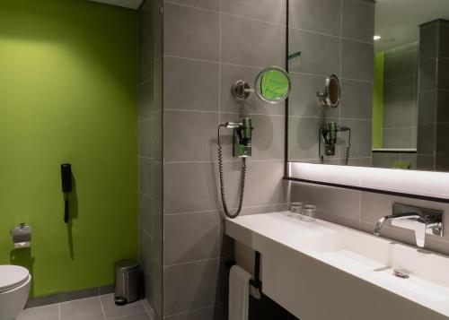 a bathroom with a shower and a sink and a mirror at Al Khoory Courtyard Hotel in Dubai
