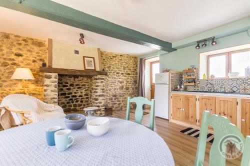 une cuisine et une salle à manger avec une table et des chaises dans l'établissement Le jardin des fées, à Savigny-le-Vieux