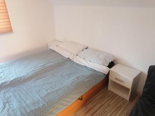 a small bedroom with a bed and a night stand at Zuta Kuca Sunca in Visoko