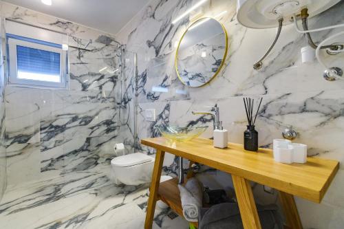 a bathroom with marble walls and a sink and a mirror at Luxury penthouse Marina - Sukošan in Sukošan