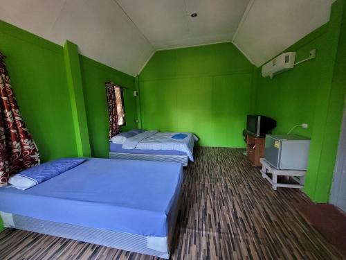 two beds in a room with green walls at Banhalawee in Ko Yao Yai