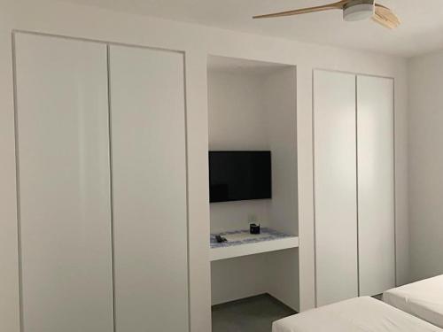 a bedroom with a tv and a white cabinet at Casa del Faro in Torre Canne