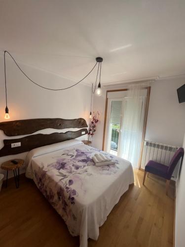 a bedroom with a large bed and a window at ENTRECAMIÑOS in O Pedrouzo