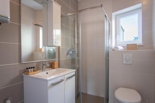 een badkamer met een toilet, een wastafel en een douche bij Noa West Residence in Novalja