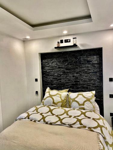 une chambre avec un lit et un mur de briques dans l'établissement Sarlat-la-Canada appartement entier magnifique, à Sarlat-la-Canéda