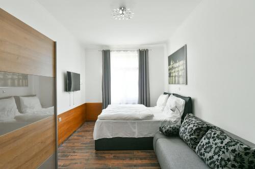 a living room with a bed and a couch at Apartmány Na Náměstí 85 in Jindrichuv Hradec
