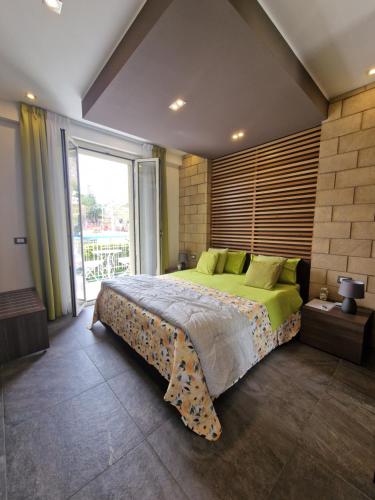 a bedroom with a large bed and a large window at Mongibello Palace B&B in Mondello