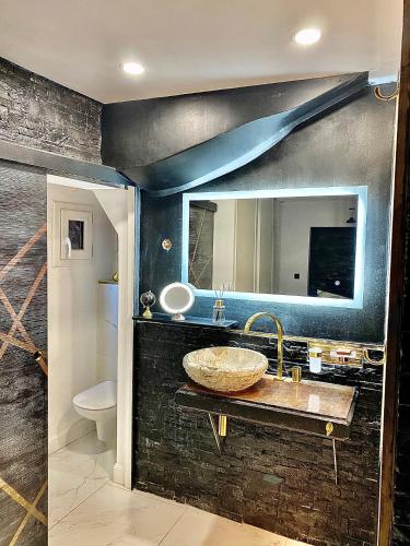 une salle de bain avec un lavabo et un miroir dans l'établissement Sarlat-la-Canada appartement entier magnifique, à Sarlat-la-Canéda