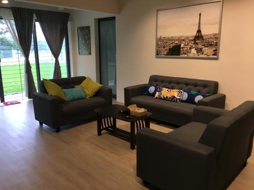 a living room with two couches and a table at Ode to Joy in Serendah