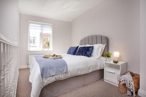 - une chambre blanche avec un grand lit et une fenêtre dans l'établissement Cobblers Cottage, à Sidmouth