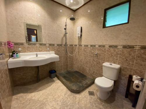 uma casa de banho com um WC, um lavatório e um chuveiro em Minang Cove Resort em Ilha Tioman