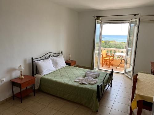 Schlafzimmer mit einem Bett und Meerblick in der Unterkunft Hotel Marialena in Archangelos