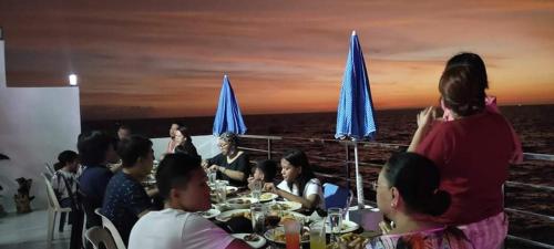 a group of people sitting at a table on a boat at The Philip Ann Resort in Mabini