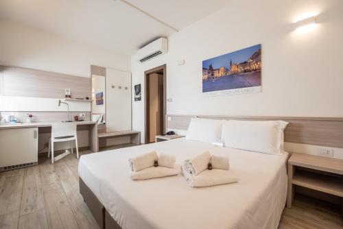 a bedroom with a large white bed with two pillows at Best Quality Hotel Politecnico in Turin