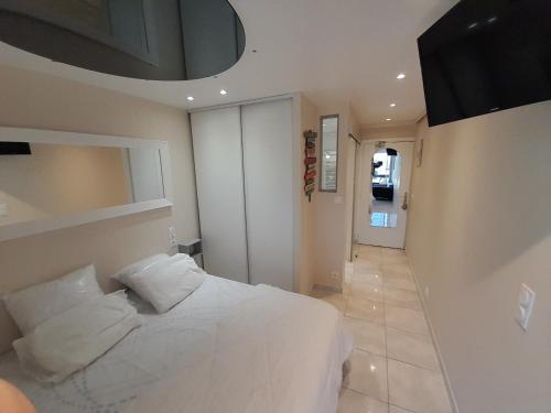 - une chambre avec un lit blanc et un couloir dans l'établissement Appartement Village Naturiste Mojito, au Cap d'Agde