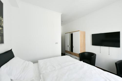 a bedroom with a bed and a tv on the wall at Apartmány Na Náměstí 85 in Jindrichuv Hradec