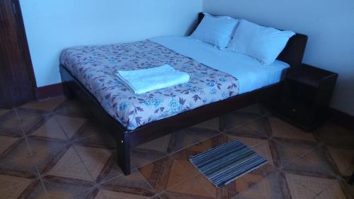 - un petit lit dans une chambre dotée d'un mur bleu dans l'établissement Lucia Villas Mbale, à Mbale