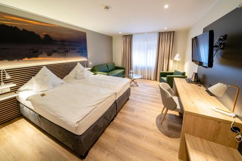 Habitación de hotel con cama y escritorio en Hotel Restaurant Kloppendiek en Vreden