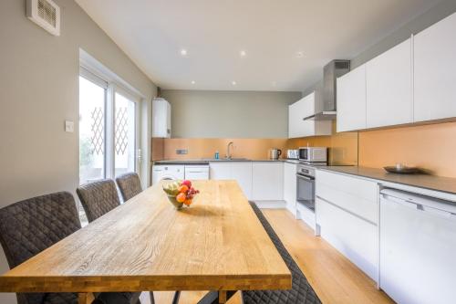 a kitchen with a wooden table with a bowl of fruit on it at Sillwood Mews - With Free Parking in Brighton & Hove