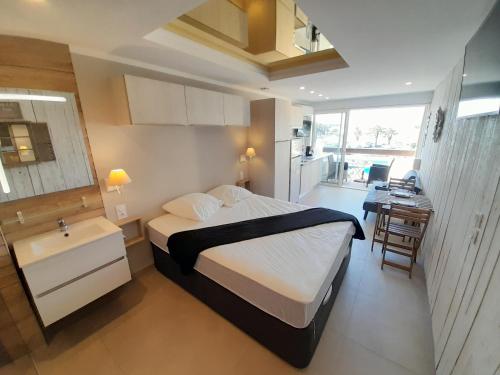 une chambre avec un lit, un bureau et un lavabo dans l'établissement Appartement Village Naturiste Cosy, au Cap d'Agde