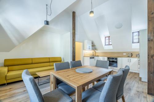a dining room with a table and chairs and a couch at Residence Wurmfeld - Rodinný apartmán s 3 ložnicemi in Český Krumlov