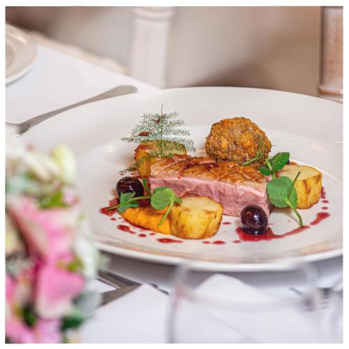 a plate of food with meat and vegetables on a table at Last Drop Village Hotel & Spa in Bolton