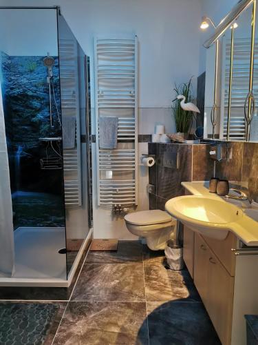a bathroom with a sink toilet and a shower at Pension Zur Alten Post in Havelberg